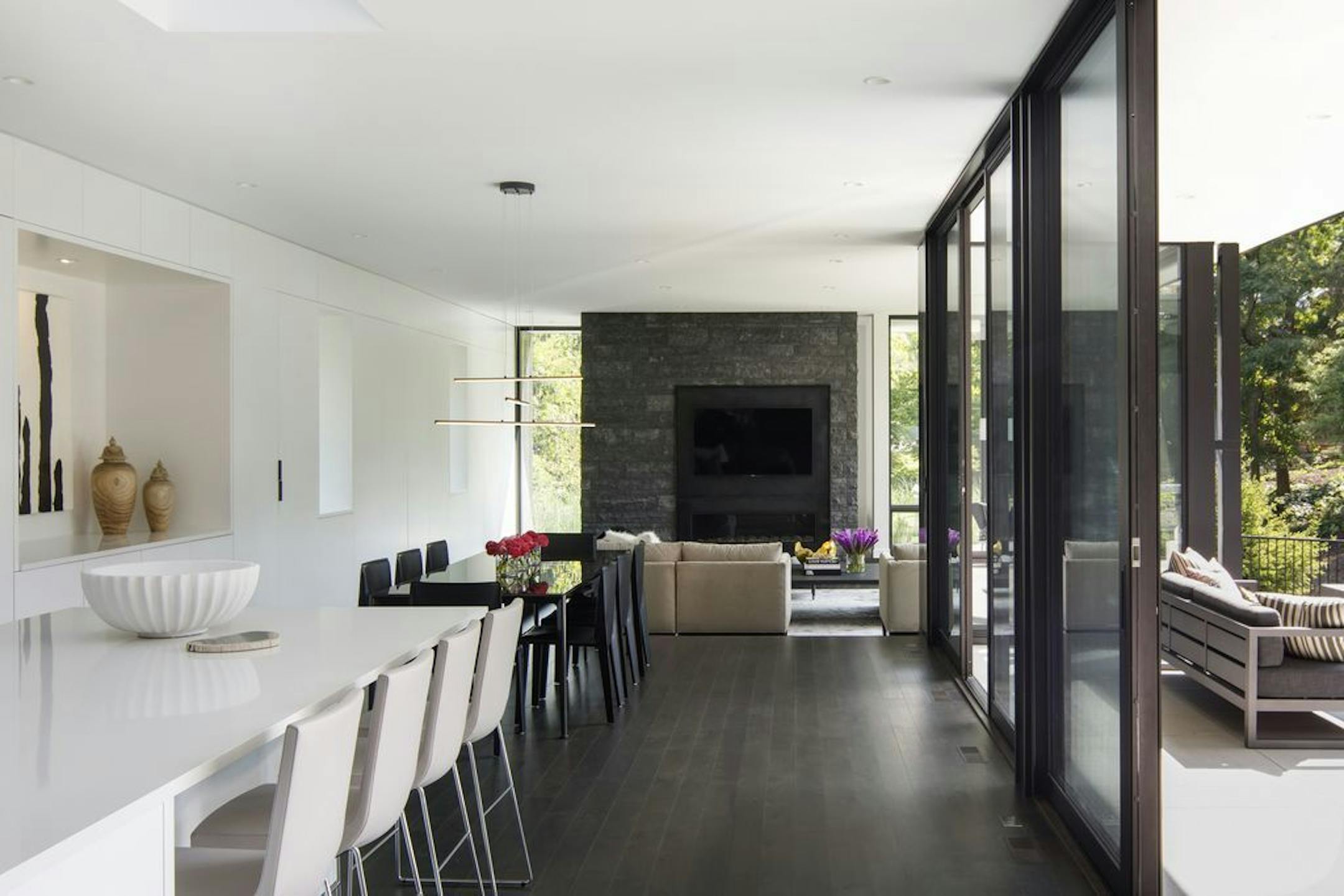 The open floor plan, top, is shaped by one wall of crisp white cabinetry and one wall of glass facing a south patio, designed by Peterssen/Keller Architecture..