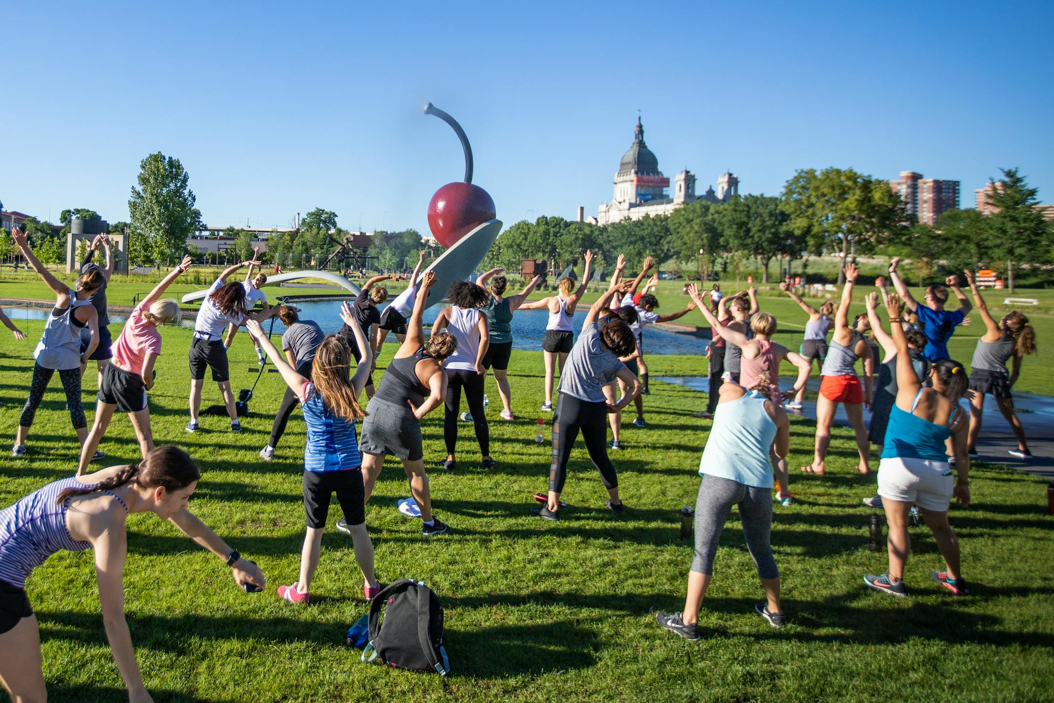 Workout participants stretch at "Spoonbridge and Cherry" on Thursday, July 5, 2018.