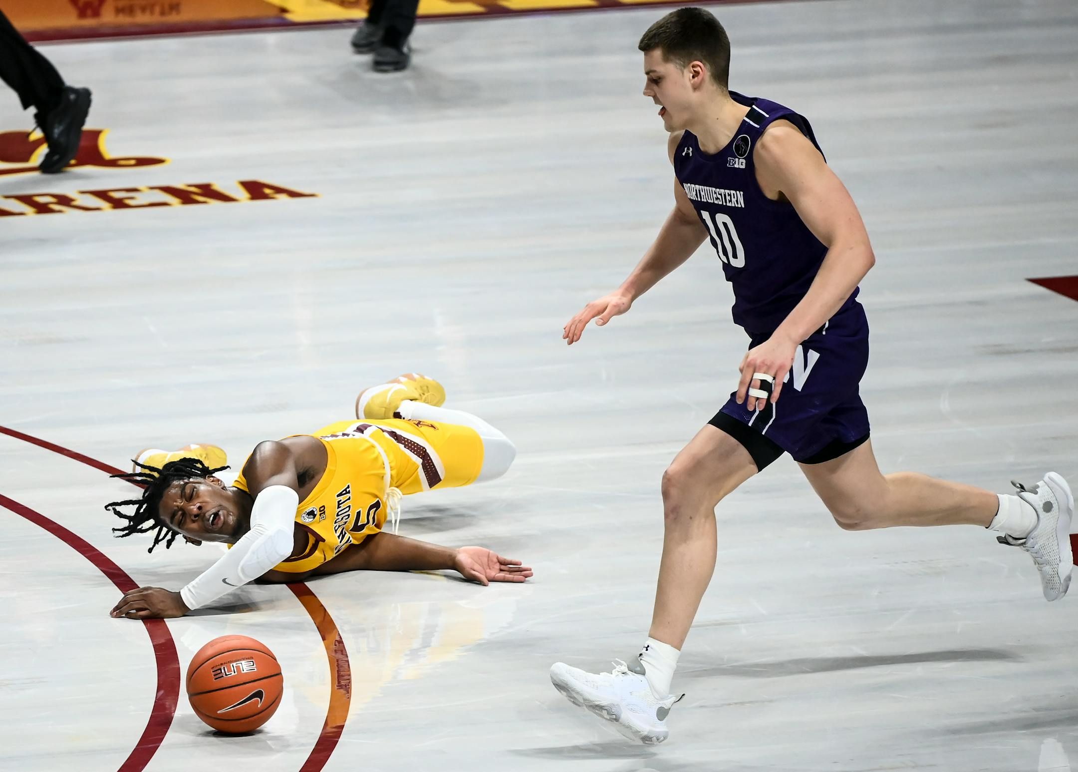 Northwestern Wildcats forward Miller Kopp (10) chased down the ball as Minnesota Gophers guard Marcus Carr (5) lost control and fell to the court in the second half.