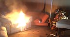St. Paul fire fighters Chris Parsons, President of Minnesota Professional Fire Fighters, and Pete Gutzmann monitor a couch fire set at a training faci