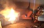 St. Paul fire fighters Chris Parsons, President of Minnesota Professional Fire Fighters, and Pete Gutzmann monitor a couch fire set at a training faci
