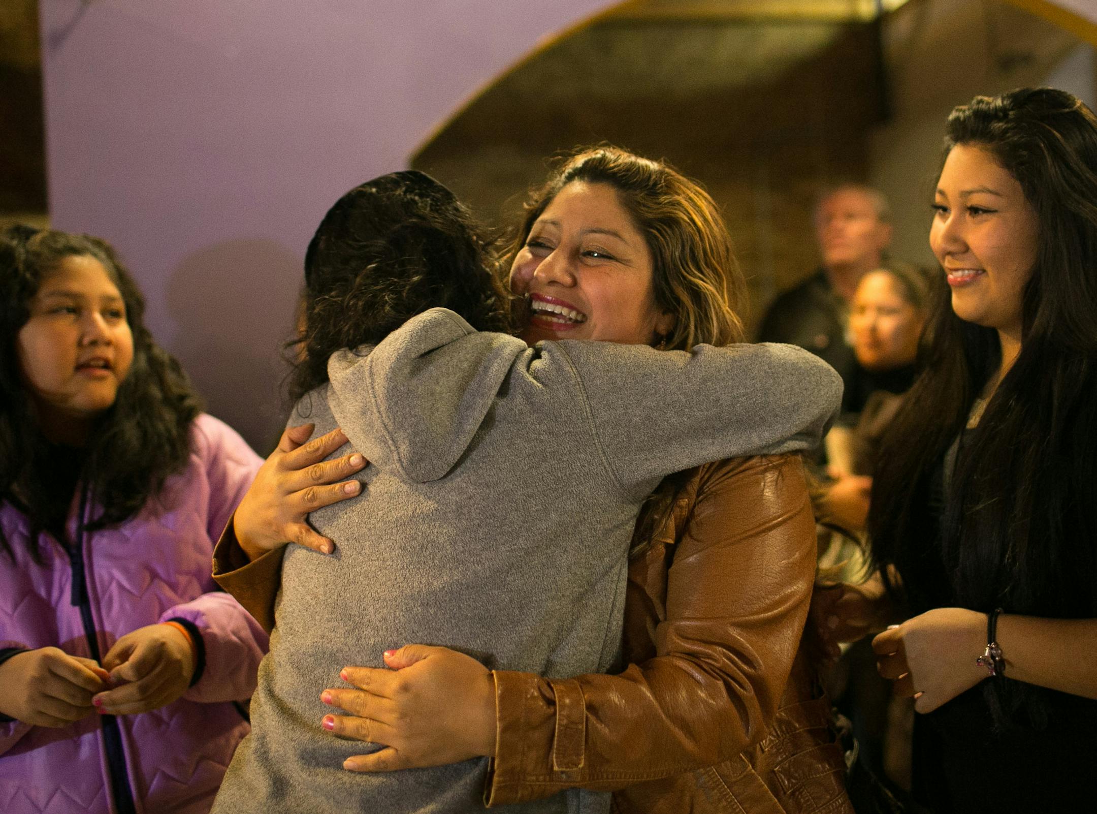 Alvina Cruz, right of center, shares an embrace with Maria Olson after the conclusion of President Obama's speech on immigration reform Thursday, Nov. 20, 2014 at Mercado Central. ] AARON LAVINSKY • aaron.lavinsky@startribune.com Activists watch as President Obama announces an executive order on immigration that will shield as many as 5 million immigrants nationally and thousands in Minnesota from the threat of deportation. Photographs taken at Mercado Central Thursday, Nov. 20, 2014 in M