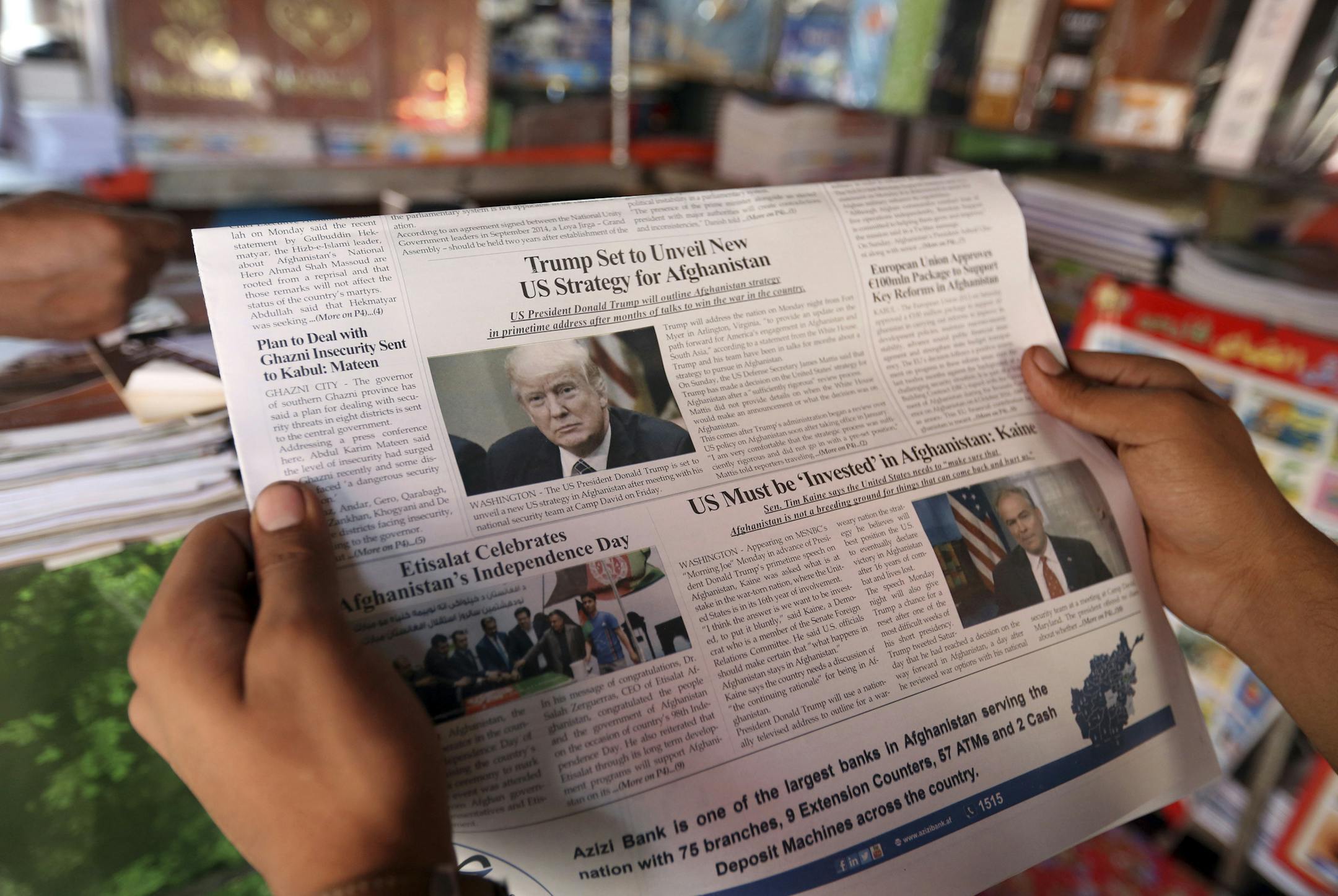 An Afghan man reads a local newspaper with photo of the U.S. President Donald Trump in Kabul, Afghanistan, Tuesday, Aug. 22, 2017. Reversing his past calls for a speedy exit, Trump recommitted the United States to the 16-year-old war in Afghanistan Monday night, declaring U.S. troops must "fight to win." (AP Photo/Rahmat Gul)