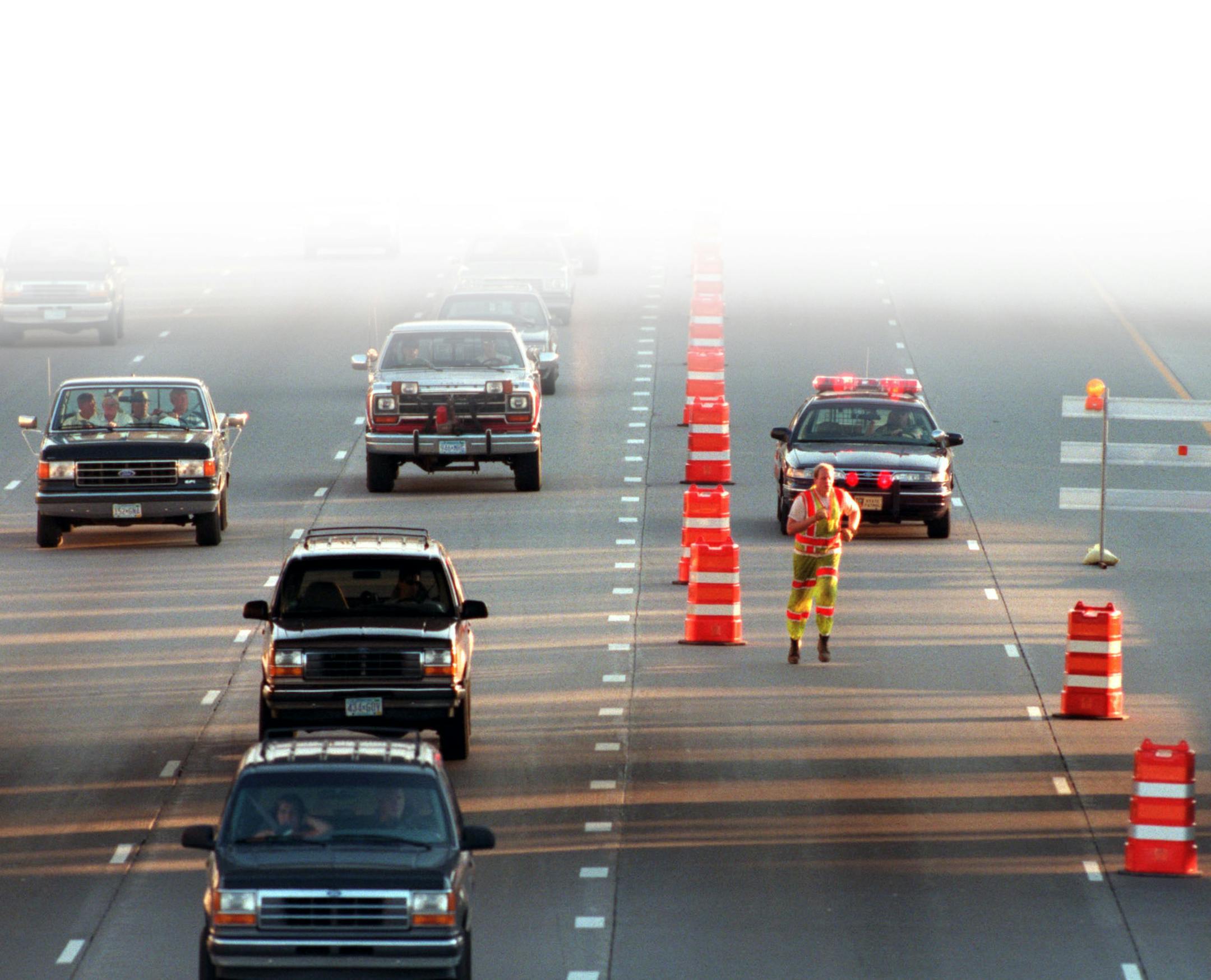 Brian Gilmore an employee of Warning Lites of Minnesota, dashes towards a barrel in the north bound lane of35E in downtown St. Paul Thursday evening. The Minnesota Department of Transportation will be resurfacing a 6 mile section of Interstate Hwy 35E form St. Paul north through Maplewood and Little Canada to Shoreveiw. That 6 mile section will be closed nightly during the hours of 8pm- 5:30 am. Most of the work is being done at night to lessen problems for commuters. ORG XMIT: MIN20130705193549
