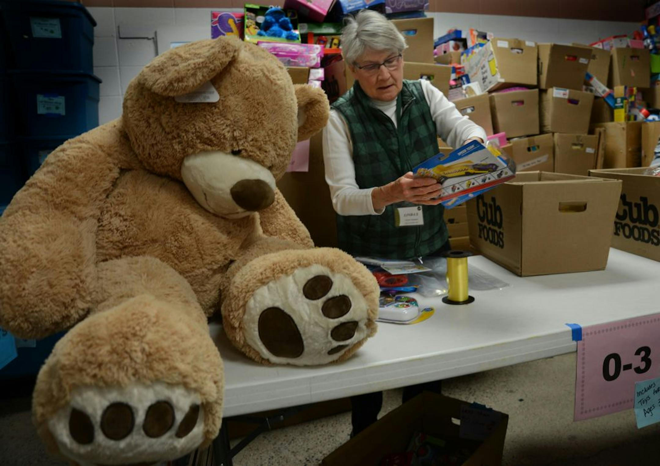 Volunteer Linda Smith of Minneapolis helped sort through toys in the company of a massive stuffed bear that would become a Christmas gift for some child.