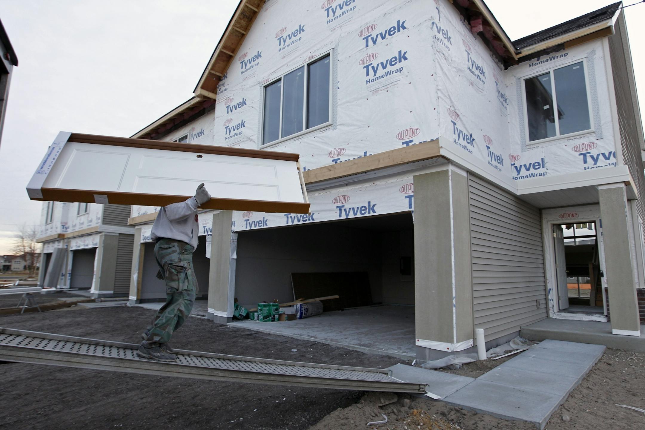 John Piotrowski of Schwieters Companies delivers doors to town homes under construction at a Rottlund Homes building site in Blaine.