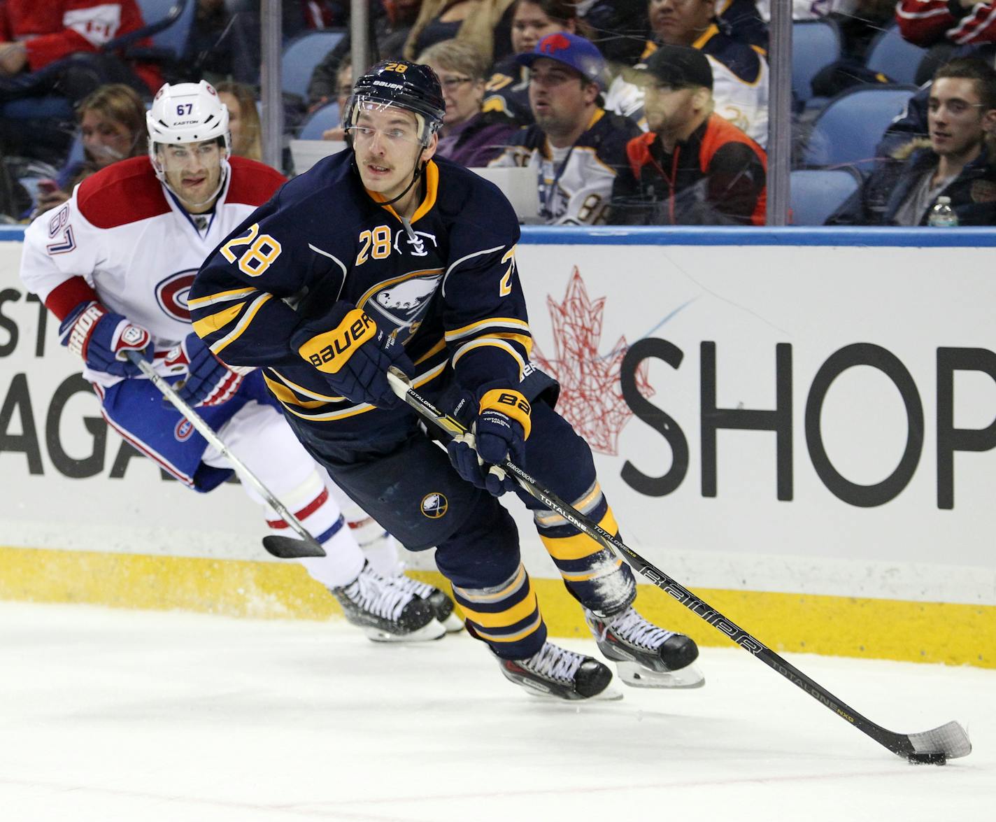 Buffalo Sabres' Zemgus Girgensons (28), of Latvia, carries the puck along the boards against Montreal Canadiens' Max Pacioretty (67) during the second period of an NHL hockey game Wednesday, Nov. 5, 2014, in Buffalo, N.Y. Montreal defeated Buffalo 2-1 iin a shootout. (AP Photo/Jen Fuller)