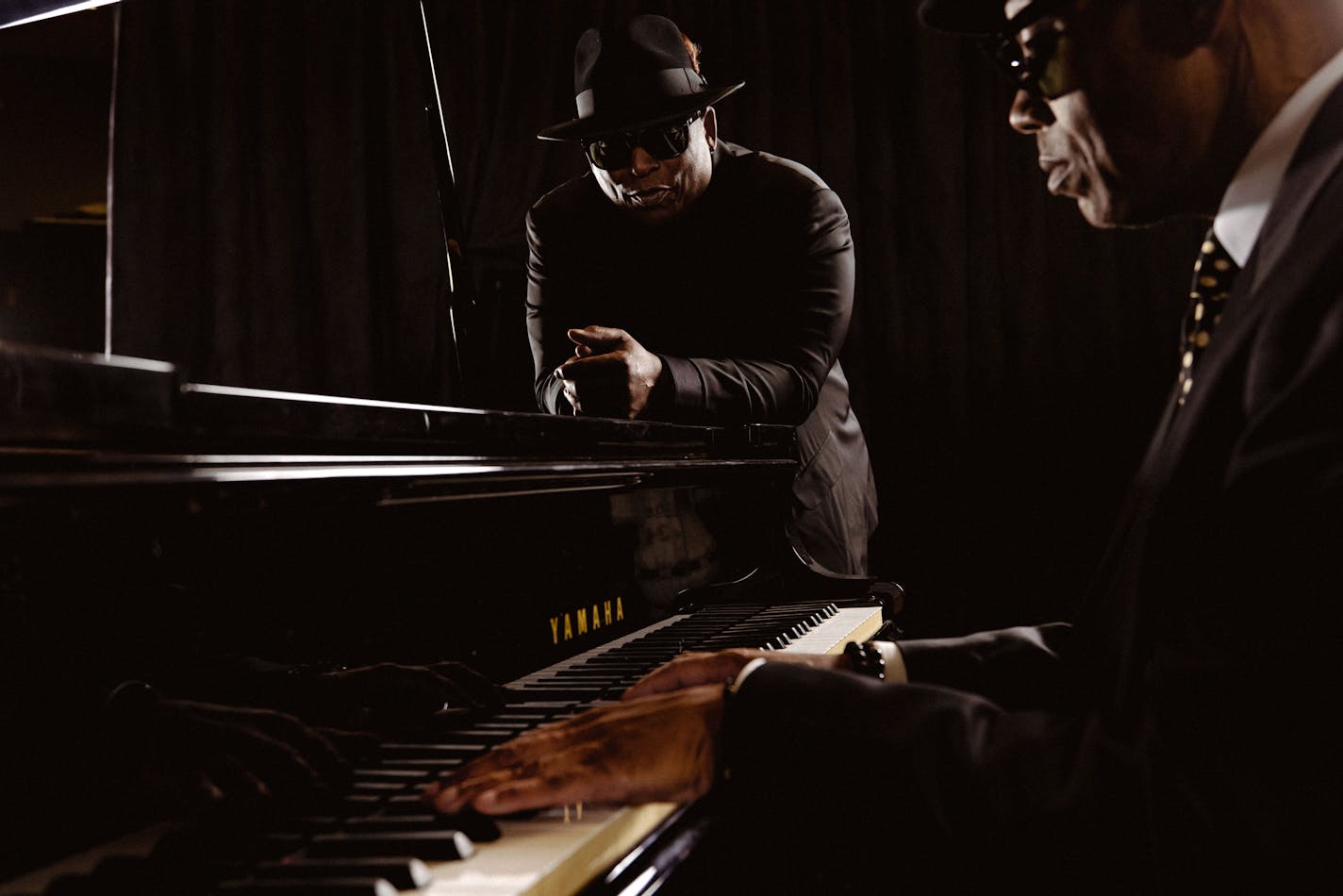 Jimmy Jam (pictured playing the piano) and Terry Lewis (pictured leaning on the piano) singing and harmonizing together. Photographed in their production recording studio Flyte Tyme in Los Angeles.