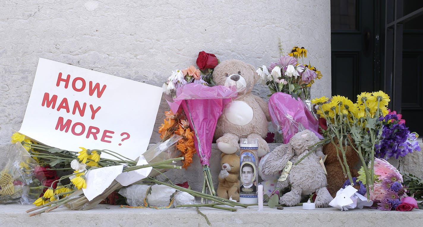 Candles, flowers and signs were left outside of the Ohio Statehouse in Columbus following mass shootings in El Paso, Texas., and Dayton, Ohio, on Monday, Aug. 5, 2019. (Barbara J. Perenic/The Columbus Dispatch via AP)