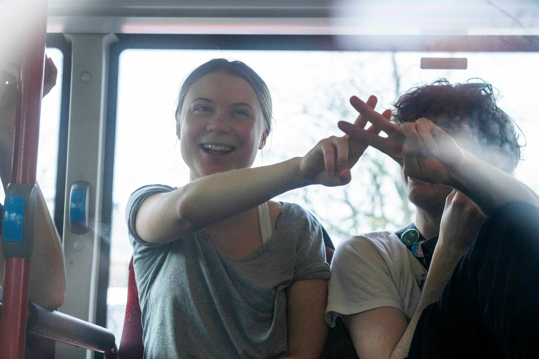 Climate activist Greta Thunberg flashes a V-sign after being detained and driven off in a bus after joining protestors who blocked a road during a climate protest by Extinction Rebellion and other activists near the Dutch parliament in The Hague, Netherlands, Saturday, April 6, 2024.