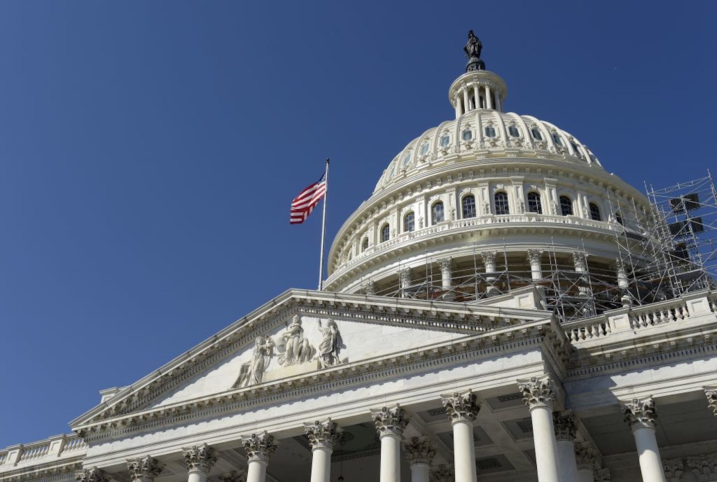 FILE - In this Tuesday, Sept. 6, 2016, file photo, an American flag flies over Capitol Hill in Washington, as lawmakers return from a 7-week break. The federal government recorded a deficit of $107.1 billion in August, slightly lower than the July deficit. But the imbalance through 11 months of this budget year is up sharply from a year ago, reflecting higher spending and lower-than-expected tax revenues.