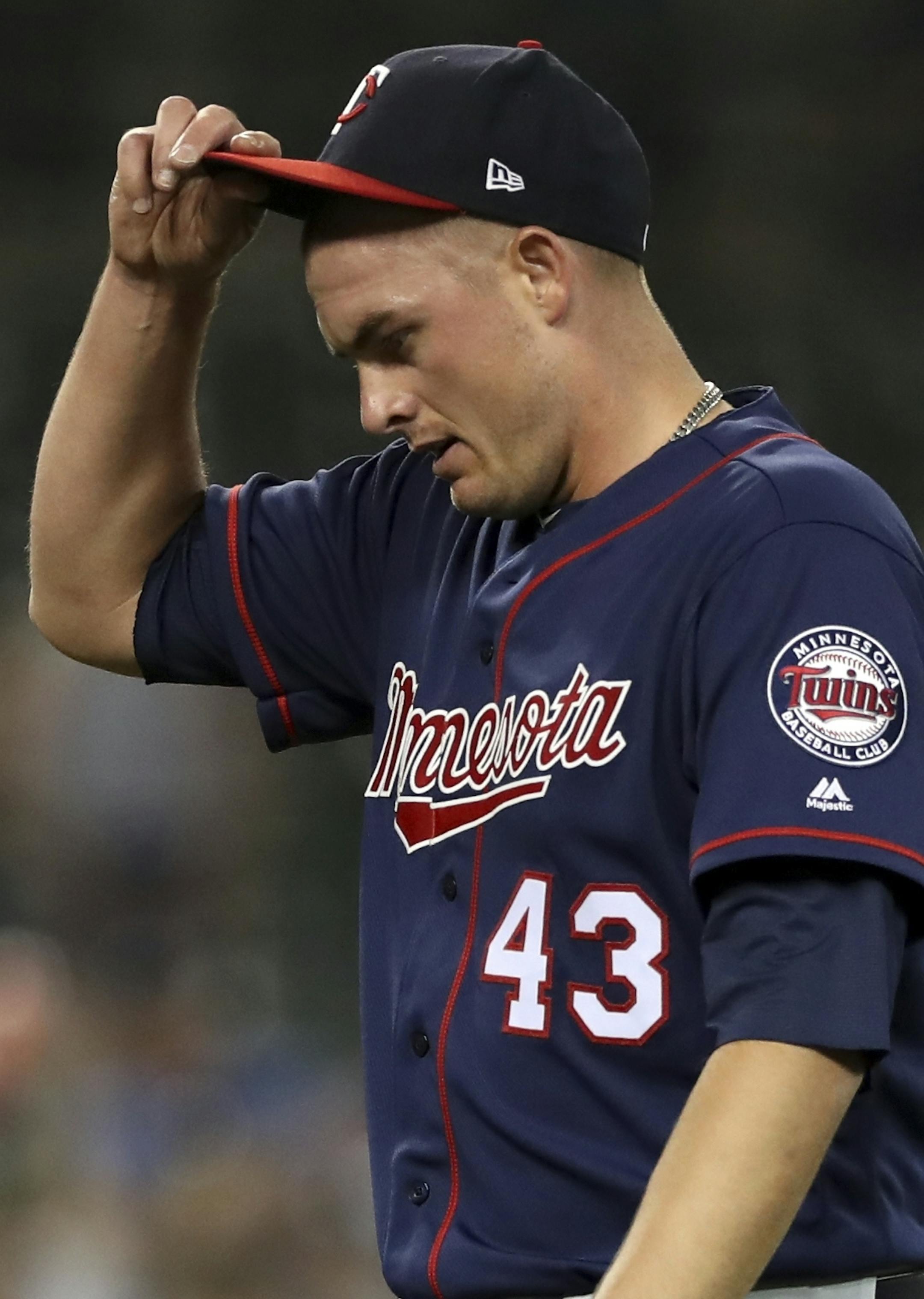 Minnesota Twins relief pitcher Addison Reed walks to the dugout after being removed during the eighth inning of the team's baseball game against the Detroit Tigers, Wednesday, June 13, 2018, in Detroit. (AP Photo/Carlos Osorio)