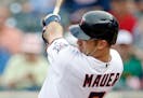 Minnesota Twins' Joe Mauer follows through on his RBI triple off Baltimore Orioles pitcher Ubaldo Jimenez in the first inning of a baseball game Thurs
