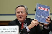 At a U.S. House hearing on Dec. 7, Tom Blanton, director of the National Security Archive at George Washington University, holds up a copy of the 1997