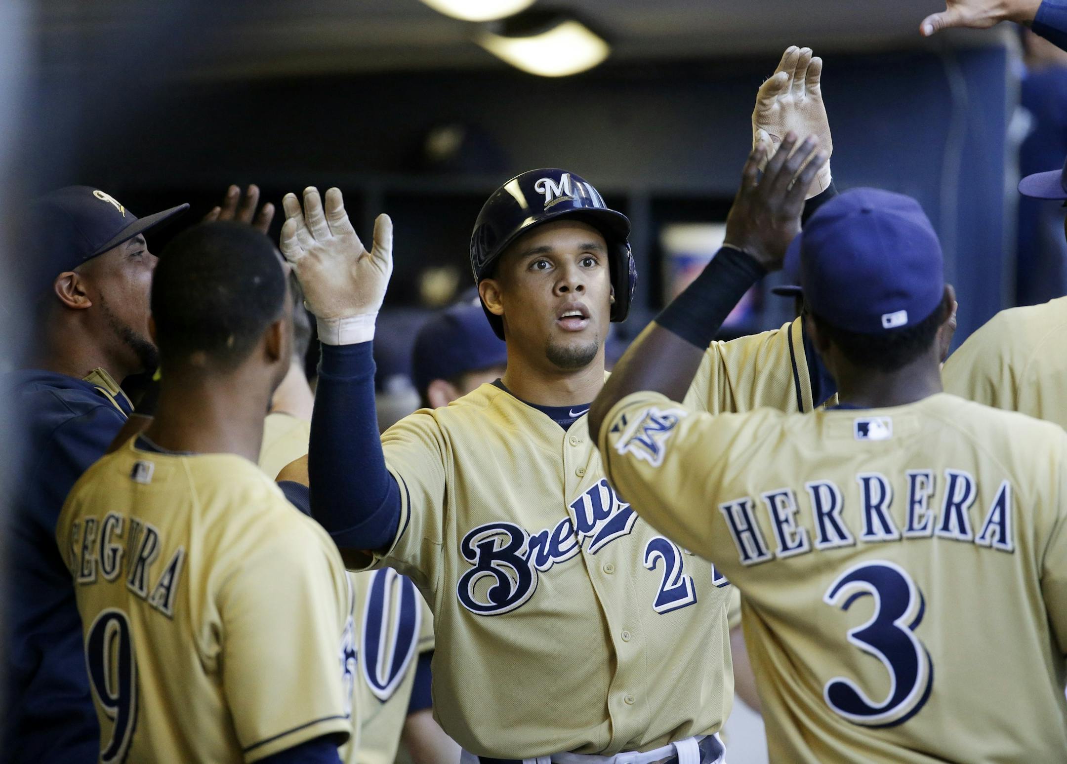 Milwaukee Brewers' Carlos Gomez is congratulated in the dugout after scoring a run during the first inning of a baseball game against the Chicago Cubs Friday, May 30, 2014, in Milwaukee. The Brewers stumbled down the stretch last season, missing the playoffs after a promising season.