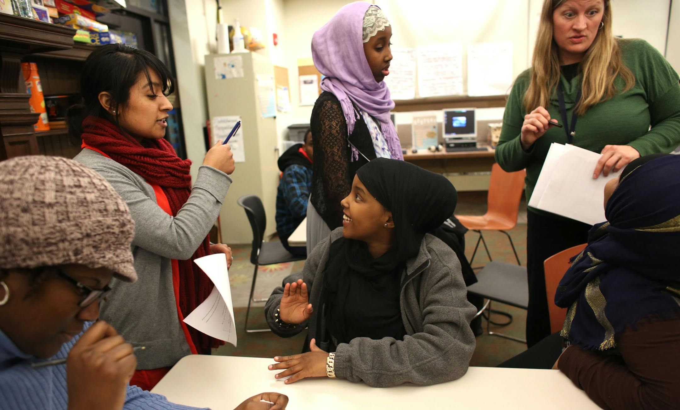 Daqka Darane, 15, center, talked with Alneida Madrigal, Urban 4-H program coordinator, while Iqbal Maxamed, 15,, in pink and black and Roodo Abdikadir, 14, listened to instruction from Kathryn Sharpe, a program manager for the Minnesota Urban 4-H Youth Development program through the University of Minnesota Extension Service, during a meeting of the Franklin Library Urban 4-H Club in Minneapolis Saturday, December 17, 2013. ] (KYNDELL HARKNESS/STAR TRIBUNE) kyndell.harkness@startribune.com