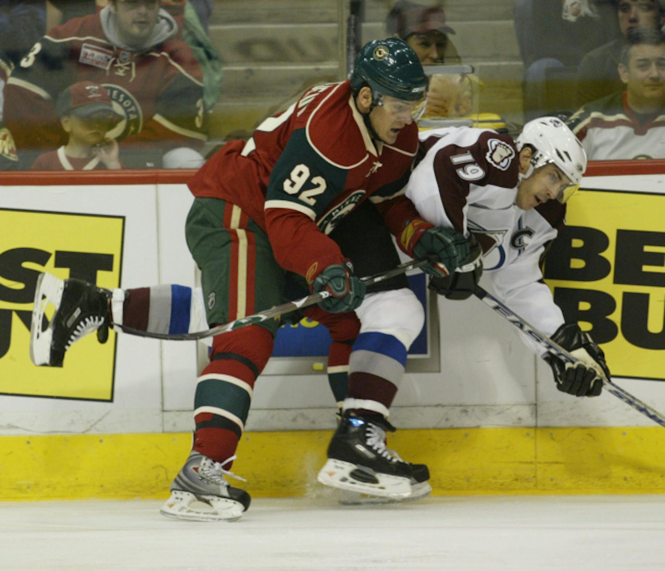 Minnesota Wild winger Branko Radivojevic (92) of Slovakia checks Colorado Avalanche center Joe Sakic (19) into the boards during the first period of a first round NHL playoff hockey game Friday, April 11, 2008 in St, Paul, Minn.