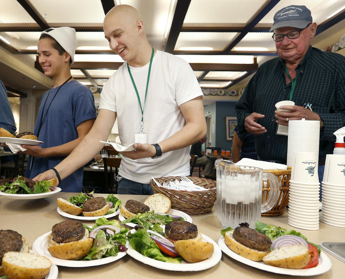 Ben Nelsen, 19, Matthew Stone, 21, both of Staples, MN and Hank Boileau of Brainerd stood in line for a meal prepared by Marin Restaurant & Bar on Wednesday at Richard M. Schulze Family American Cancer Society Hope Lodge in Minneapolis. Stone and Boileau are both guests at the Hope Lodge. Ben Nelsen was there as Matthew Stone's caretaker. ] CARLOS GONZALEZ cgonzalez@startribune.com - October 7, 2015, Minneapolis, MN, Three years after ramping up its philanthropic giving, the Richard Schulze Fami