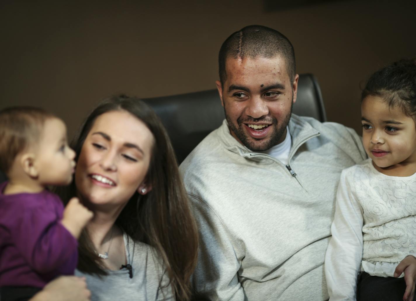 Isaac Kolstad smiled as he sat with his wife Molly and daughters Malia, 6 mo. and Haidyn,4, (on his lap) in Mankato, Minn. on Wednesday, December 18, 2014. ] REN&#xc9;E JONES SCHNEIDER reneejones@startribune.com Interview with Isaac Kolstad, 24, who survived a beating in downtown Mankato that has lead to charges against former U of M quarterback Philip Nelson.