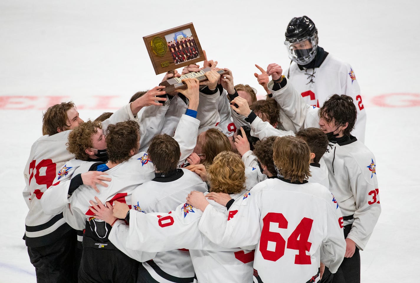 Gentry Academy players raised their trophy after winning the boys' hockey Class 1A state championship