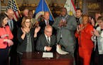 Gov. Tim Walz and advocates at a ceremonial signing Tuesday.