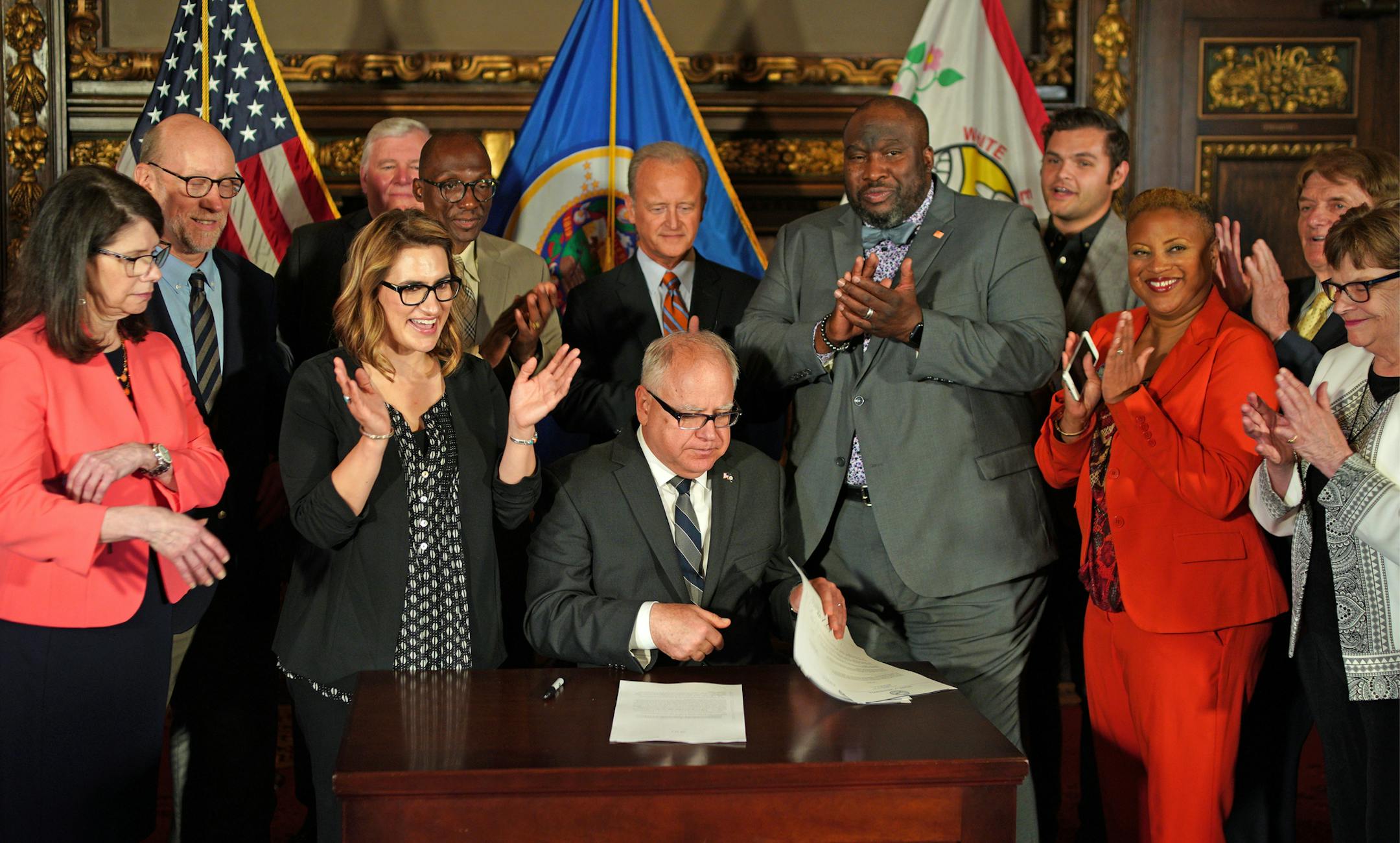 Gov. Tim Walz and advocates at a ceremonial signing Tuesday.