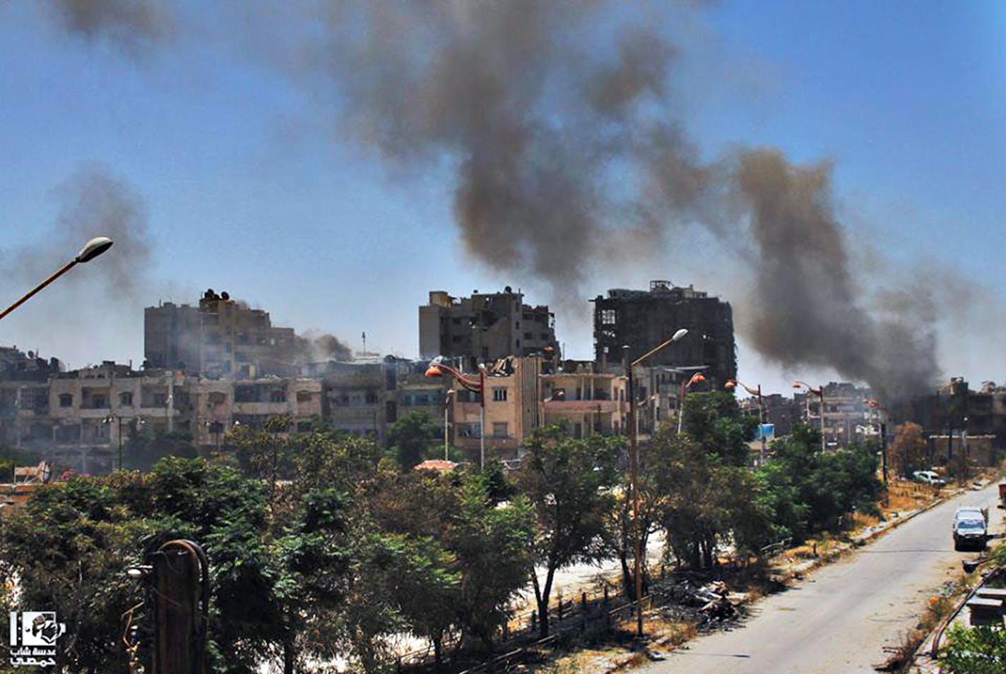 In this Sunday, July 7, 2013, citizen journalism image provided by Lens Young Homsi, which has been authenticated based on its contents and other AP reporting, black smoke rises from buildings damaged by Syrian government airstrikes and shelling in Homs, Syria. A Syrian government official claimed that the army wrested a contested district of the key city from rebels on Monday after ten days of fierce fighting. But two activists based in the city denied the claim, saying rebels were under heavy