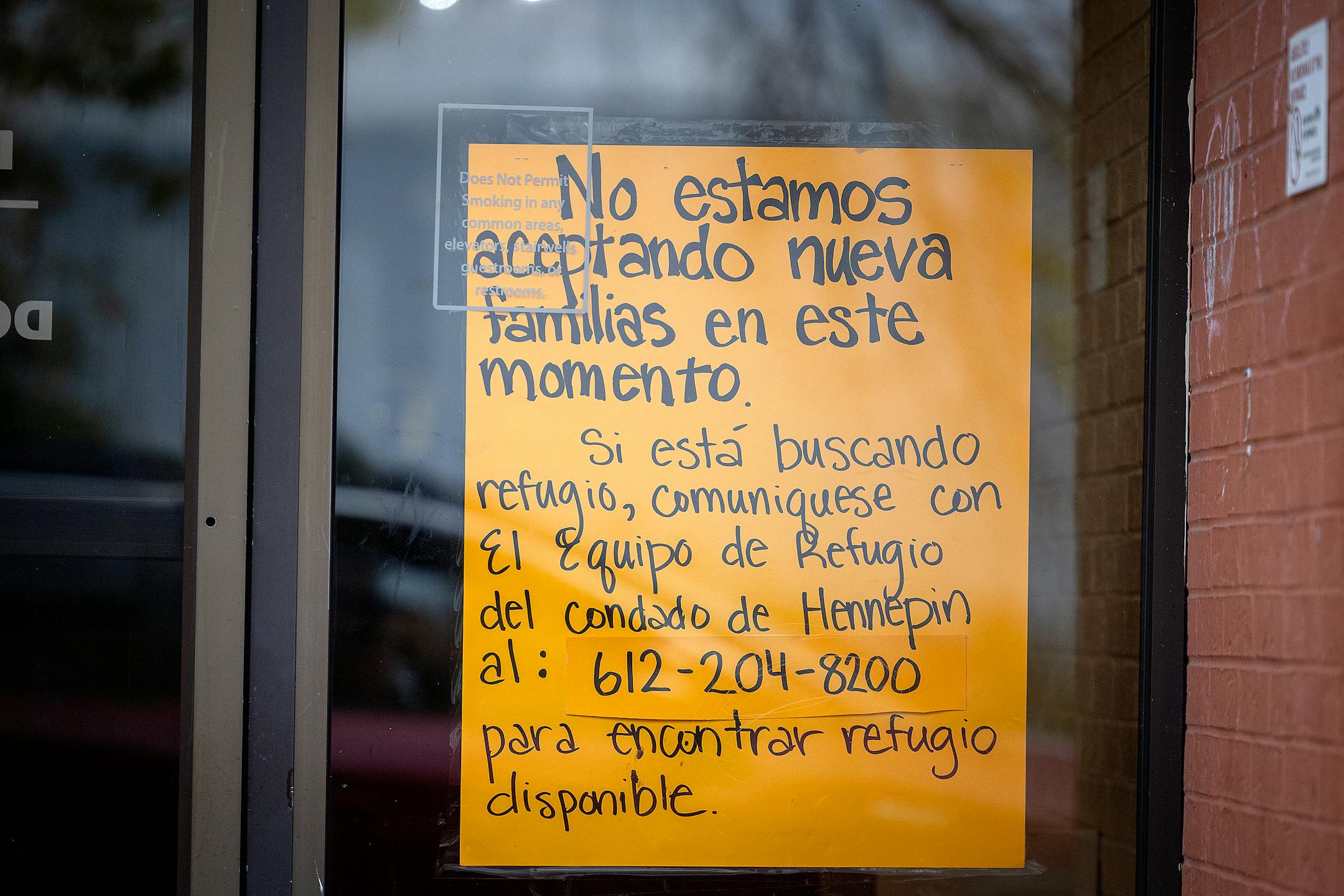 A sign that states that the shelter is no longer accepting families and referring them to a hotline in Spanish is posted on a homeless family shelter in Bloomington.
