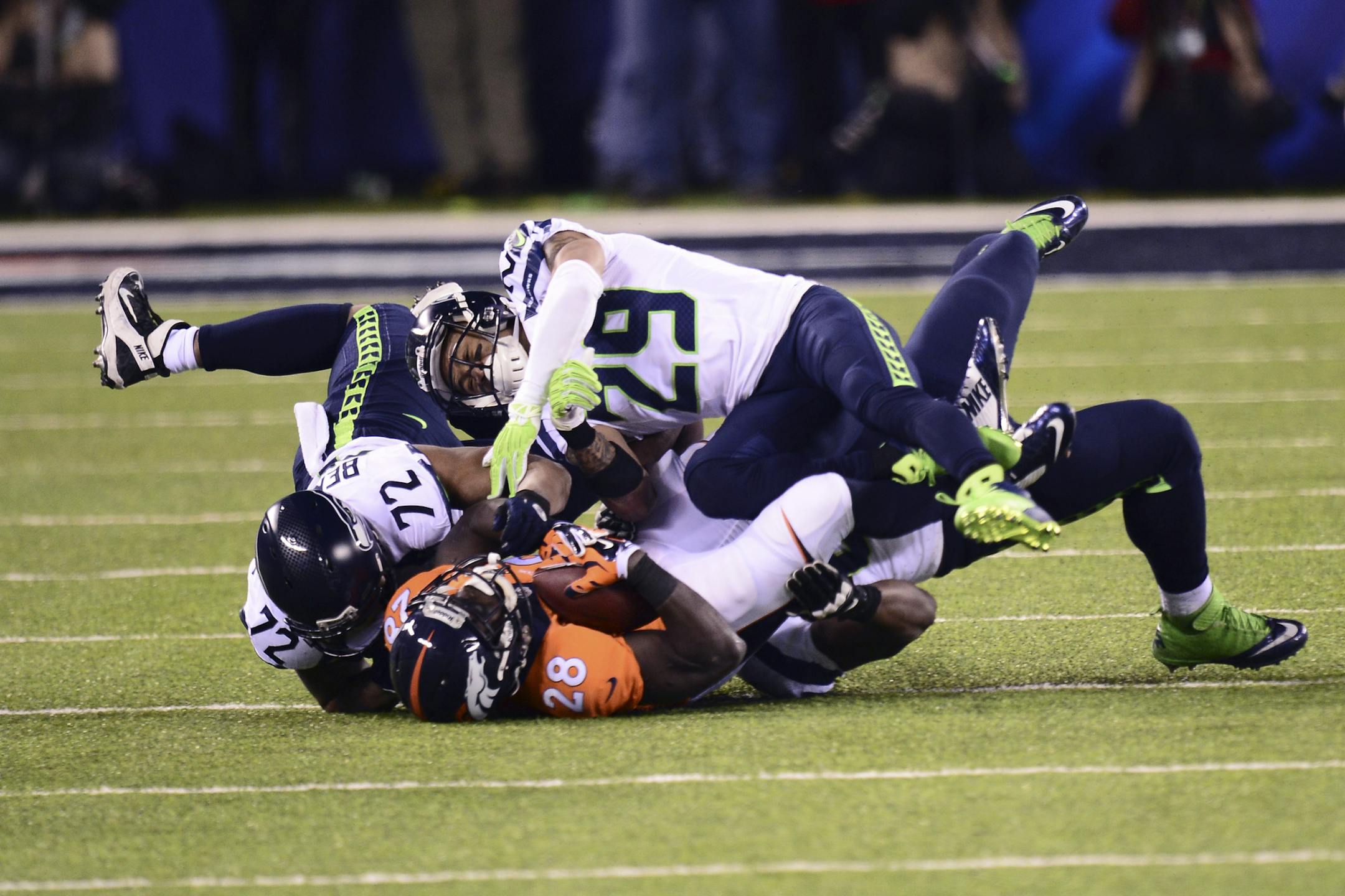 Seattle Seahawks defensive end Michael Bennett (72) and safety Earl Thomas (29) bring down Denver Broncos running back Montee Ball during the first half of the NFL Super Bowl XLVIII football game at MetLife Stadium in East Rutherford, N.J., Feb. 2, 2014. (Ben Solomon/The New York Times)