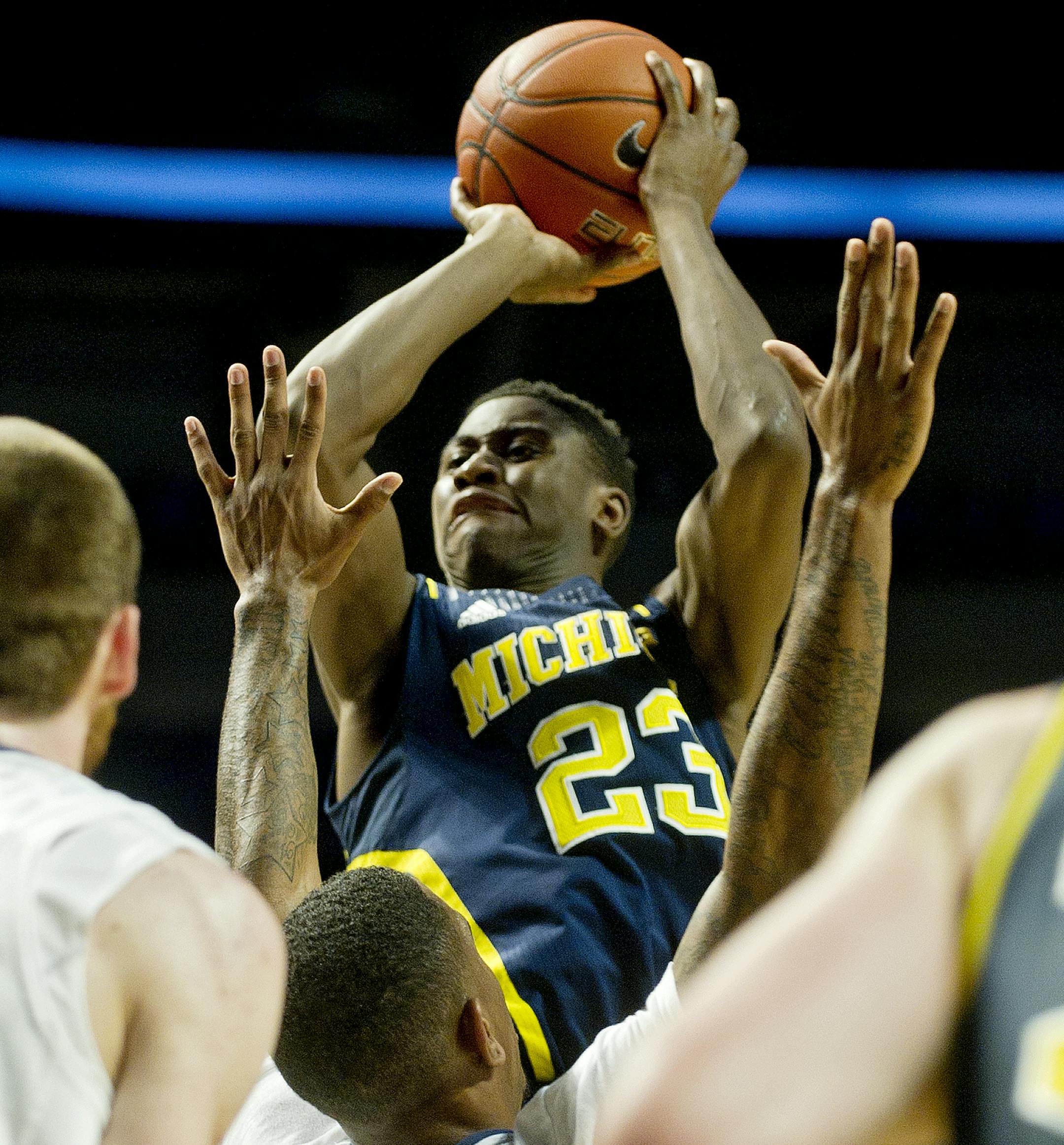Michigan's Caris LeVert shoots for a basket over Penn State defenders on Tuesday, Jan. 6, 2015, at the Bryce Jordan Center in University Park, Pa. Michigan won 73-64. (Abby Drey/Centre Daily Times/TNS)
