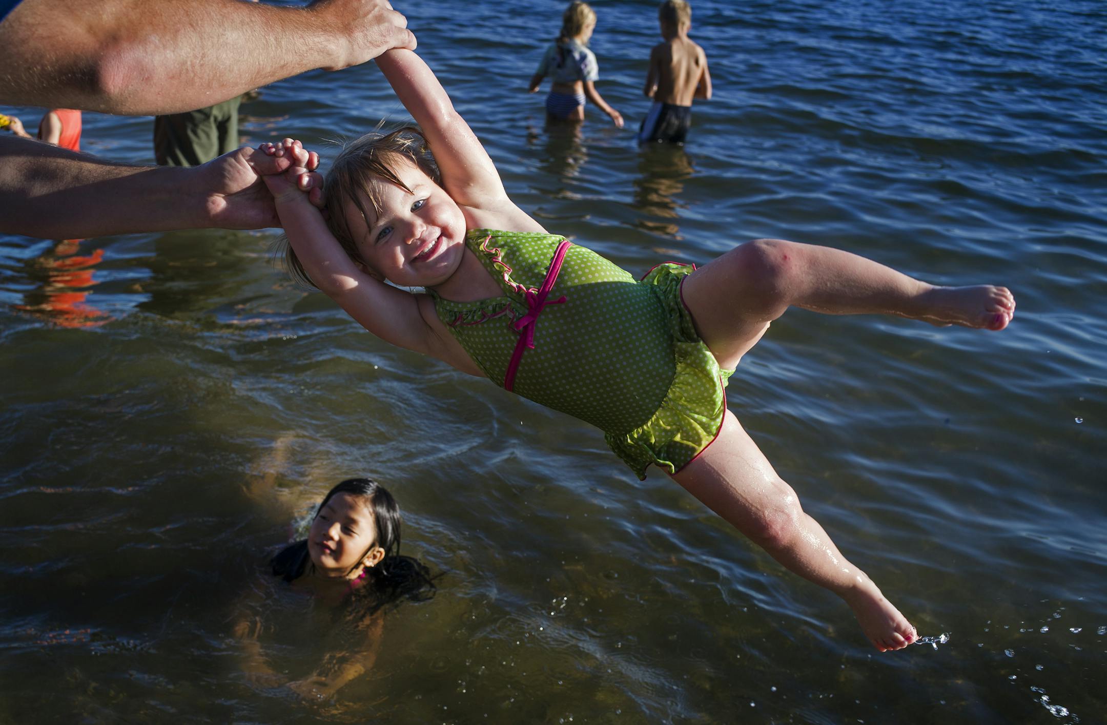 At Lake Harriet in Minneapolis, Lillian Hebert, 2, was twirled around by her dad, Nick, while her friend Evelyn Lee, 7, splashed around on Sunday.