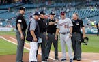 Detroit Tigers manager Ron Gardenhire poses with his son, Minnesota Twins' Toby Gardenhire and umpires, before a baseball game in Detroit, Monday, Sep