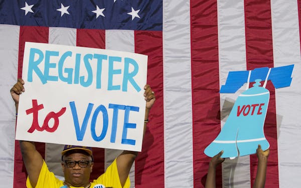FILE -- At a rally for Democratic presidential nominee Hillary Clinton, supporters hold up signs echoing her encouragement of the public to register a
