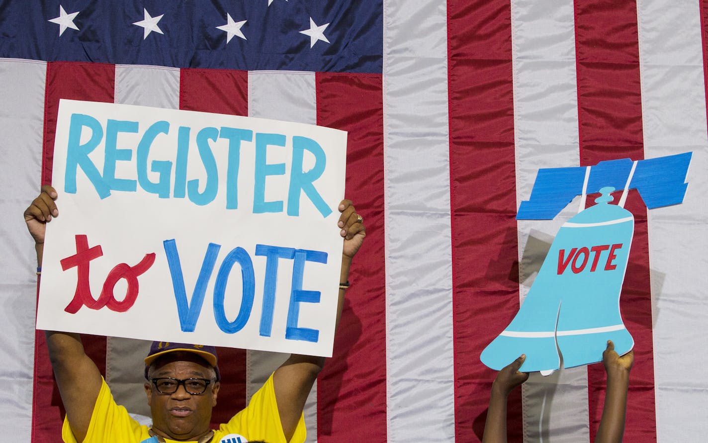 FILE -- At a rally for Democratic presidential nominee Hillary Clinton, supporters hold up signs echoing her encouragement of the public to register and vote in the election, in Philadelphia, Aug. 16, 2016. A 17-word Facebook reminder contributed to substantial increases in online voter registration across the country, according to top election officials. (Ruth Fremson/The New York Times)