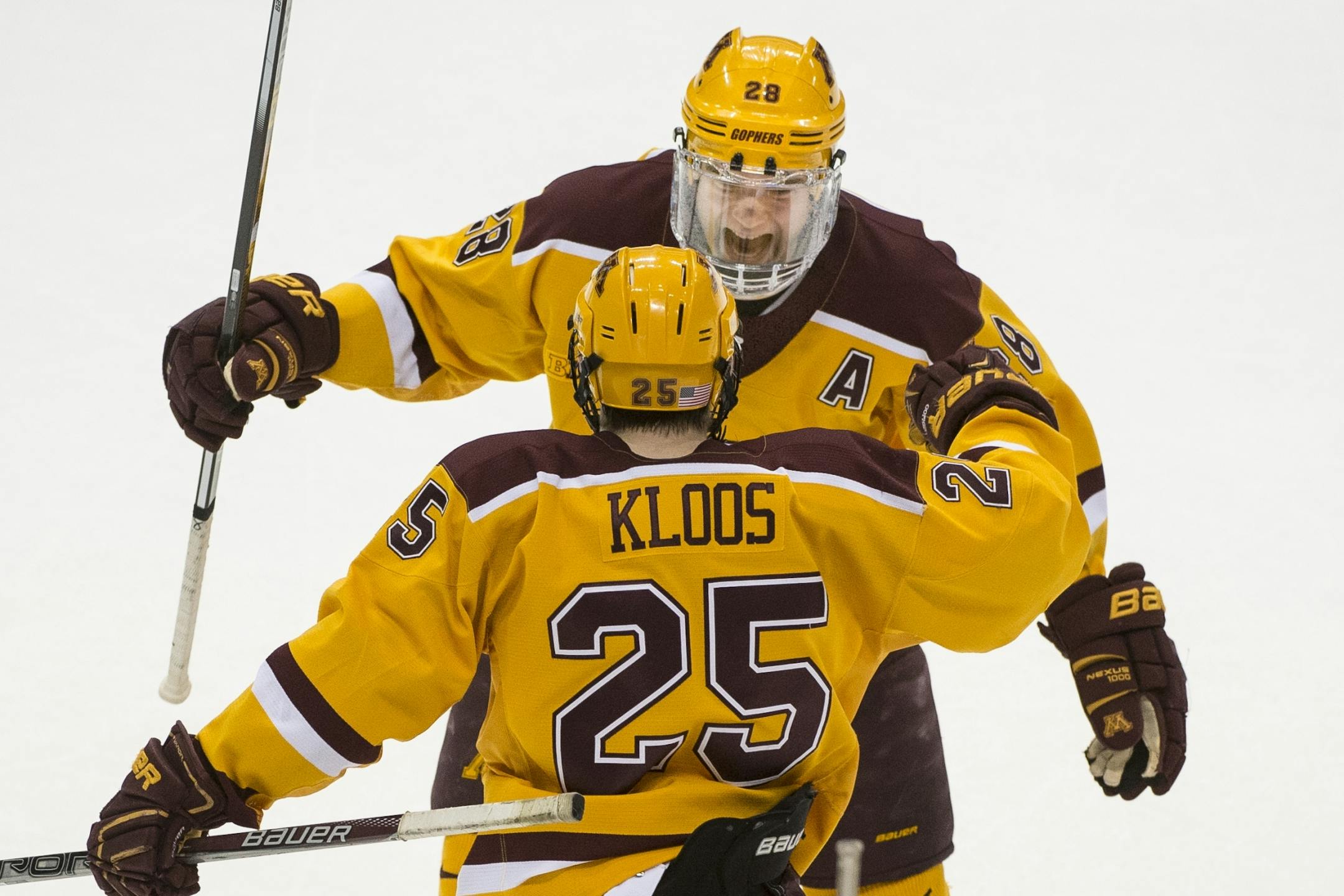Minnesota Golden Gophers defenseman Jake Bischoff (28) and Gophers center Justin Kloos (25) celebrated a goal by Kloos in the second period Saturday against the Michigan Wolverines.