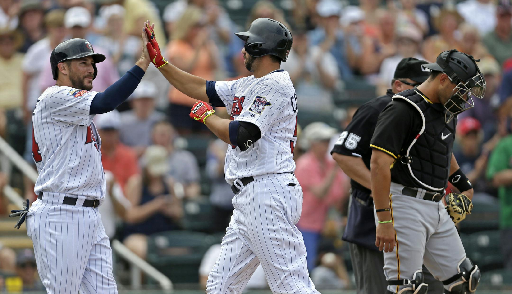 Minnesota Twins Chris Colabello, right, is greeted at the plate by Trevor Plouffe after the two scored in Colabello's two-run homer in the sixth inning of an exhibition baseball game against the Pittsburgh Pirates in Fort Myers, Fla., Wednesday, March 12, 2014. (AP Photo/Gerald Herbert)