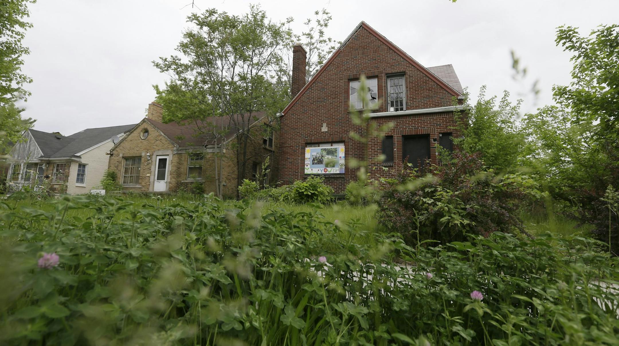 Grass and weeds grow in front of two vacant homes in Detroit, Tuesday, May 27, 2014. Removing blighted residential properties, lots and vacant commercial structures that have plagued Detroit neighborhoods for decades would cost $850 million, a task force said Tuesday. The study by the Detroit Blight Removal Task Force is part of efforts announced last year by the administration of President Barack Obama to help Detroit, which is trying to work through the largest municipal bankruptcy in U.S. his