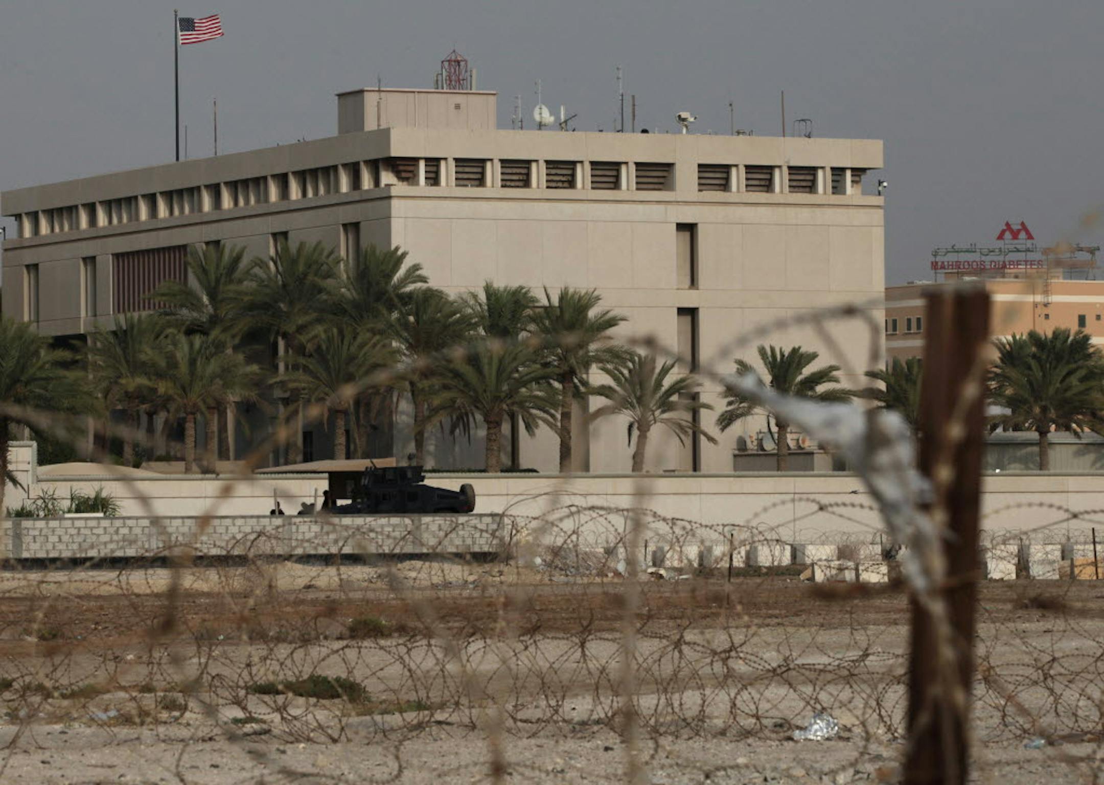 A Bahraini armored personnel vehicle and personnel reinforce U.S. Embassy security just outside of a gate to the building, surrounded in barbed wire, in Manama, Bahrain, on Sunday.