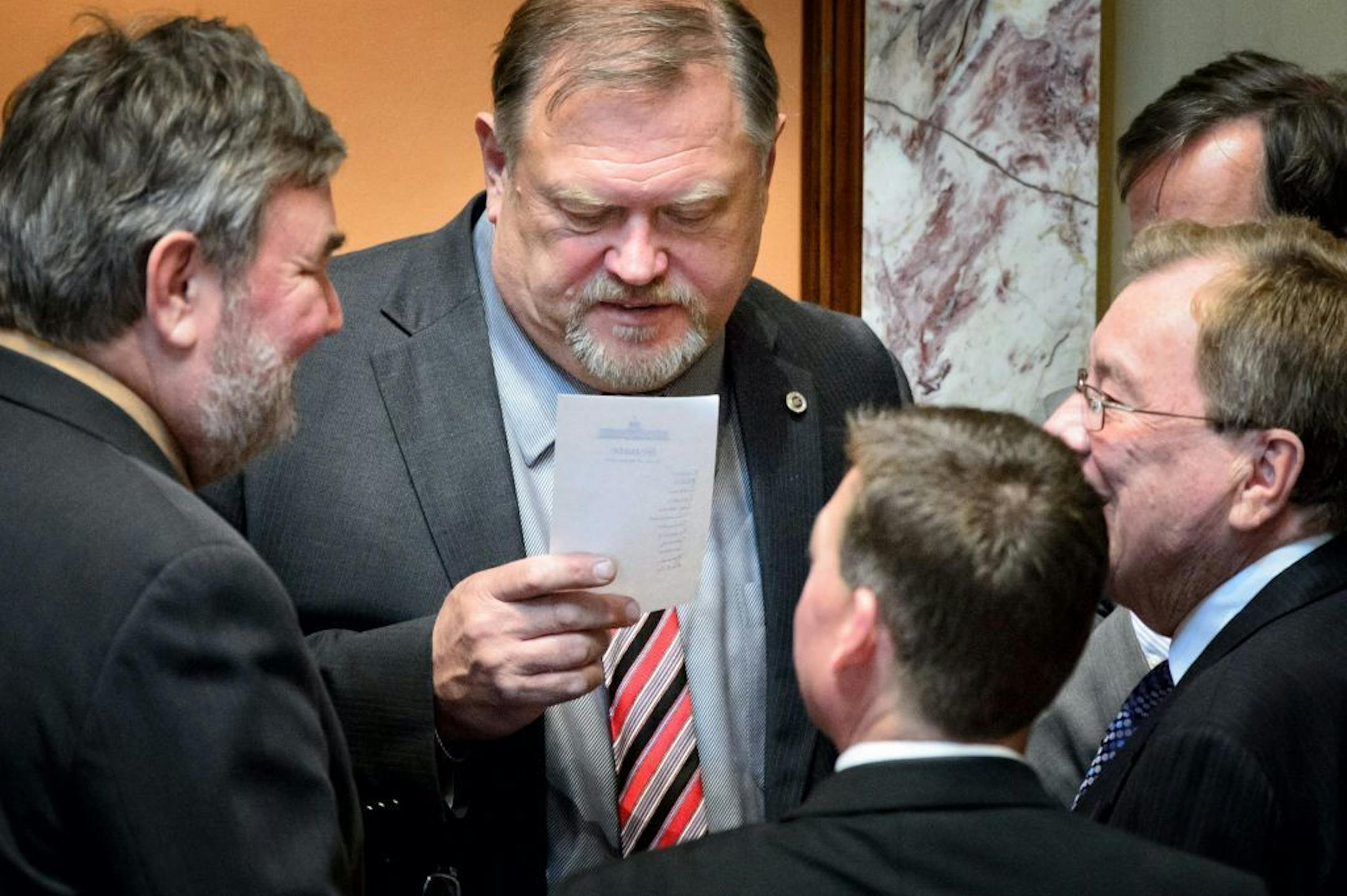 Senator Rod Skoe, DFL-Clearbrook, left, brought a list with Senator's names to Majority Leader Tom Bakk during debate on the amendment to repeal the Sunday ban. Senator Dan Sparks, DFL-Austin and the omnibus liquor bills sponsor Senator James Metzen, DFL-South St. Paul, right looked on. All of them voted against the amendment to repeal Sunday sales.