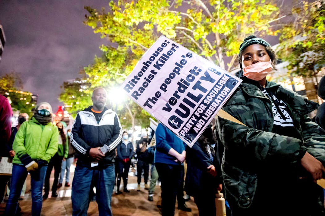 Bria Swenson holds a sign during a demonstration Friday, Nov. 19, 2021, in Oakland, Calif., following the acquittal of Kyle Rittenhouse in Kenosha, Wis. 
