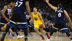 Golden State Warriors' Klay Thompson, center, drives the ball against the Minnesota Timberwolves during the second half of an NBA basketball game Thur
