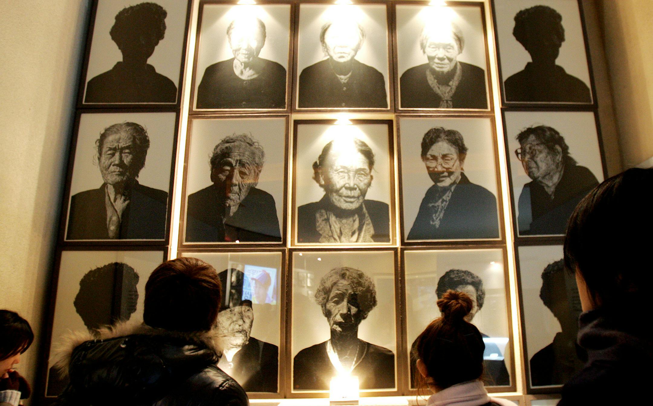 Japan's Chuo University students look at display of pictures of Korean comfort women who served as a sexual slave for the Japanese Imperial Army during the World War II, at the Historical Museum of Sexual Slavery by the Japanese Military in Gwangju, south of Seoul, Tuesday, March 6, 2007. Calls for Japan's apology for these so-called "comfort women" flared anew last week after Japanese Prime Minister Shinzo Abe said there was no proof that the women were coerced into prostitution. (AP Photo/Ahn