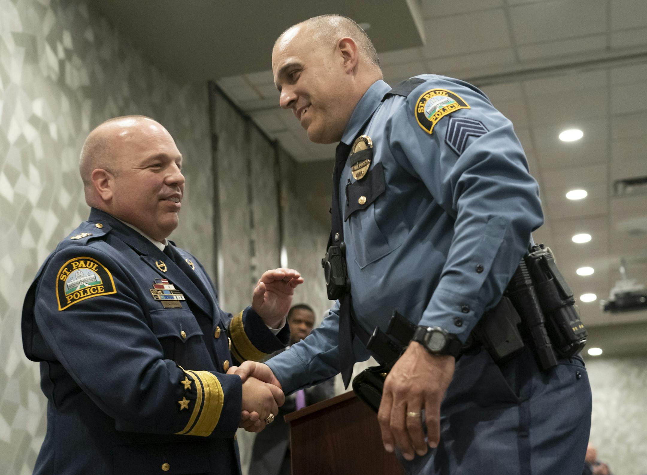 Sgt. Mike Dunaski shook St. Paul Police Chief Todd Axtell's hands as he was named Detective of the Year during a ceremony in St. Paul, Minn., on Monday, April 22, 2019. At left if St. Paul Police Chief Todd Axtell.] RENEE JONES SCHNEIDER ¥ renee.jones@startribune.com
