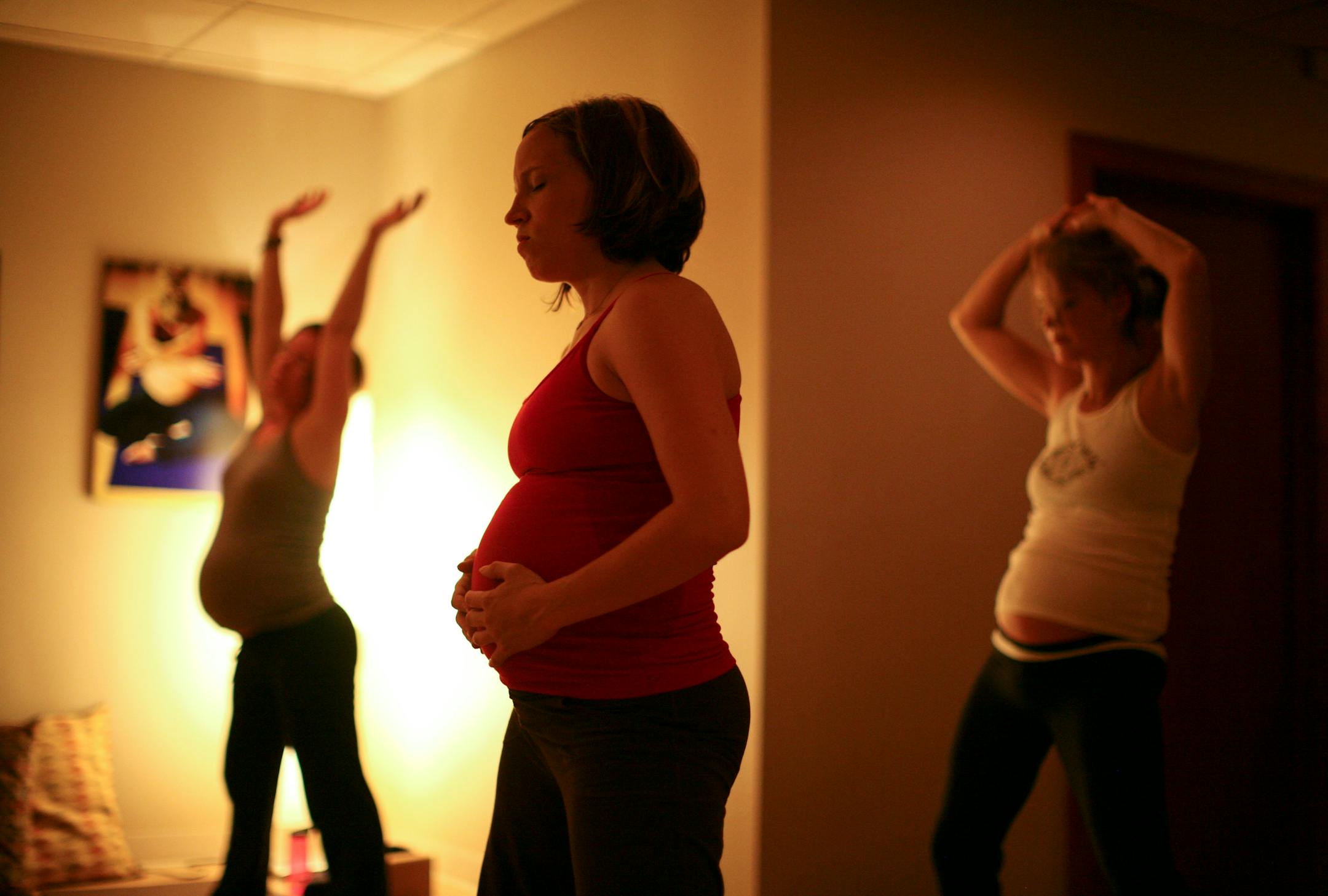 Carla Beveridge, foreground, along with Katie Frodermann, left, and Krista Margolis, right, attended a yoga class taught by the founder of the year-old studio, Sarah Longacre, at left.