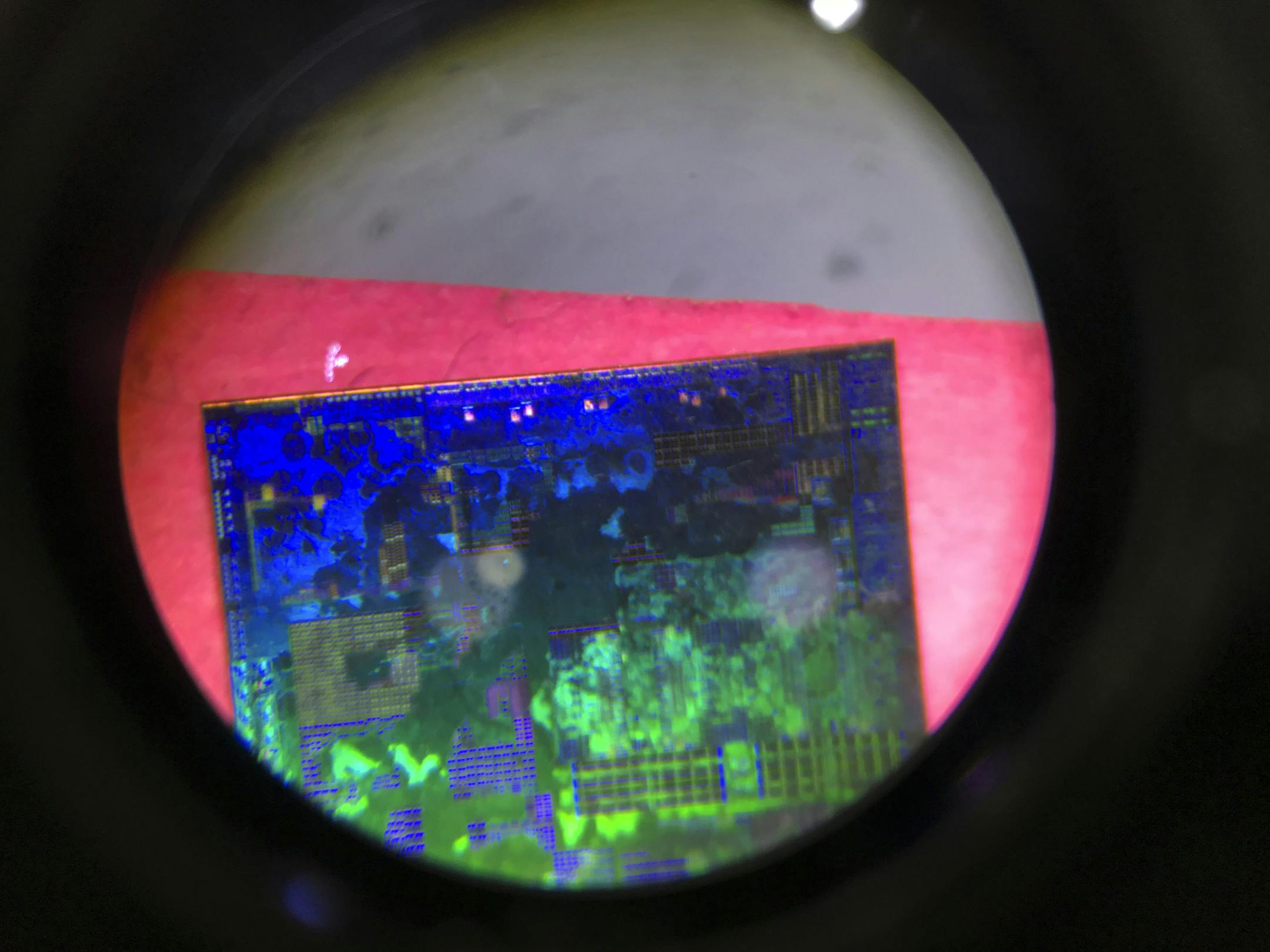 FILE - In this file photo taken Thursday, May 17, 2018, a Chinese microchip is seen through a microscope set up at the booth for the state-controlled Tsinghua Unigroup project which is driving China's semiconductor ambitions during the 21st China Beijing International High-tech Expo in Beijing, China. China is cutting taxes on its fledgling software and integrated circuit industries to spur development in the face of U.S. export controls that threaten to handicap Chinese tech companies. (AP Phot