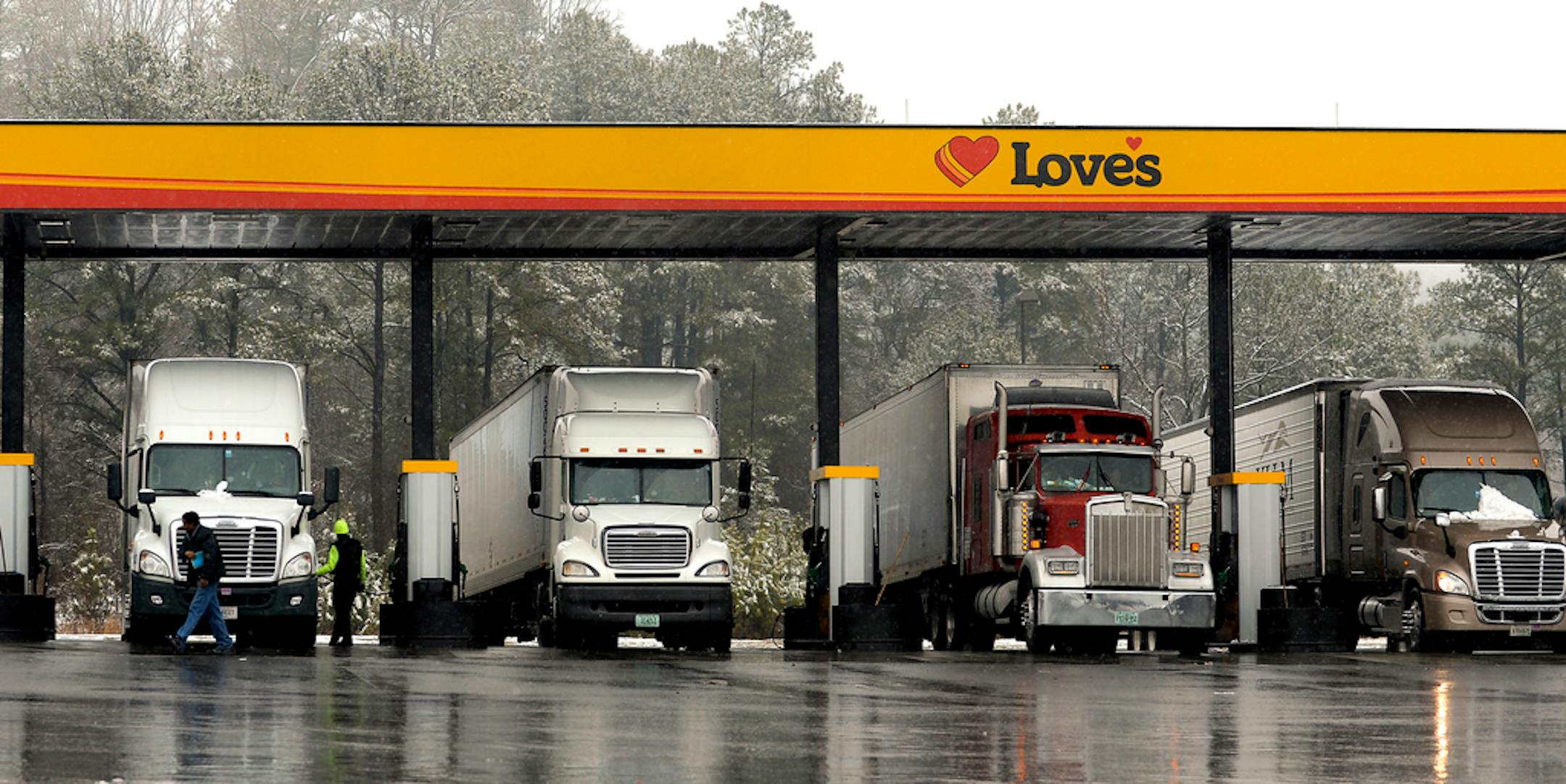 FILE - In this Feb. 11, 2014, file photo, truck drivers stop at a gas station in Emerson, Ga., north of metro Atlanta, to fill up their tractor trailer rigs. The Biden administration is proposing stronger pollution regulations for new tractor-trailer rigs that would clean up smoky diesel engines and encourage new technologies during the next two decades. The proposal released Monday by the Environmental Protection Agency would require the industry to cut smog-and-soot-forming nitrogen oxide emissions by up to 90% per truck over current standards by 2031. (AP Photo/David Tulis, File)