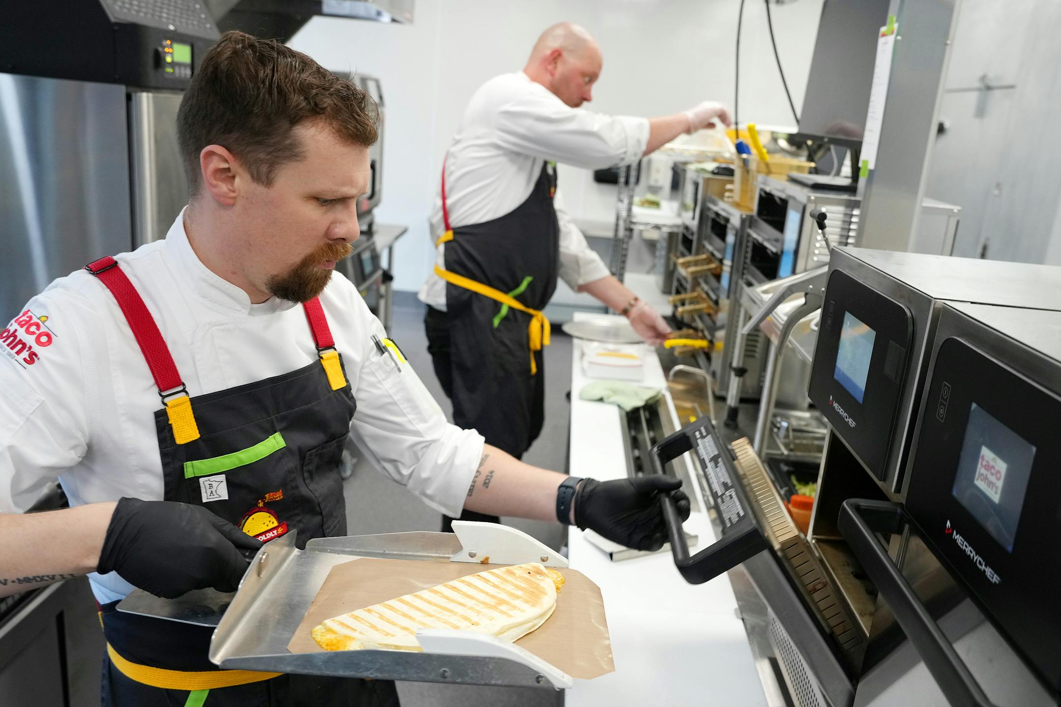 Taco John's corporate chef makes a pulled pork carnitas quesadilla at the company's new restaurant support center and test kitchen Wednesday, Nov. 9, 2022 in St. Louis Park, Minn.