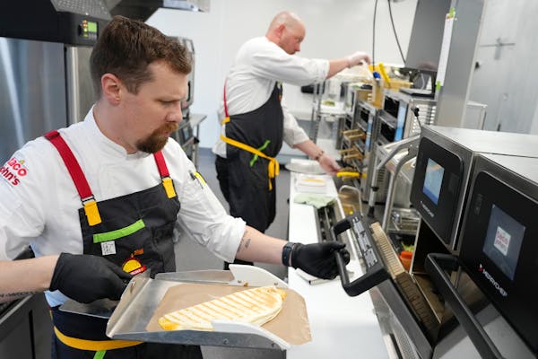 Taco John's corporate chef makes a pulled pork carnitas quesadilla at the company's new restaurant support center and test kitchen Wednesday, Nov. 9, 