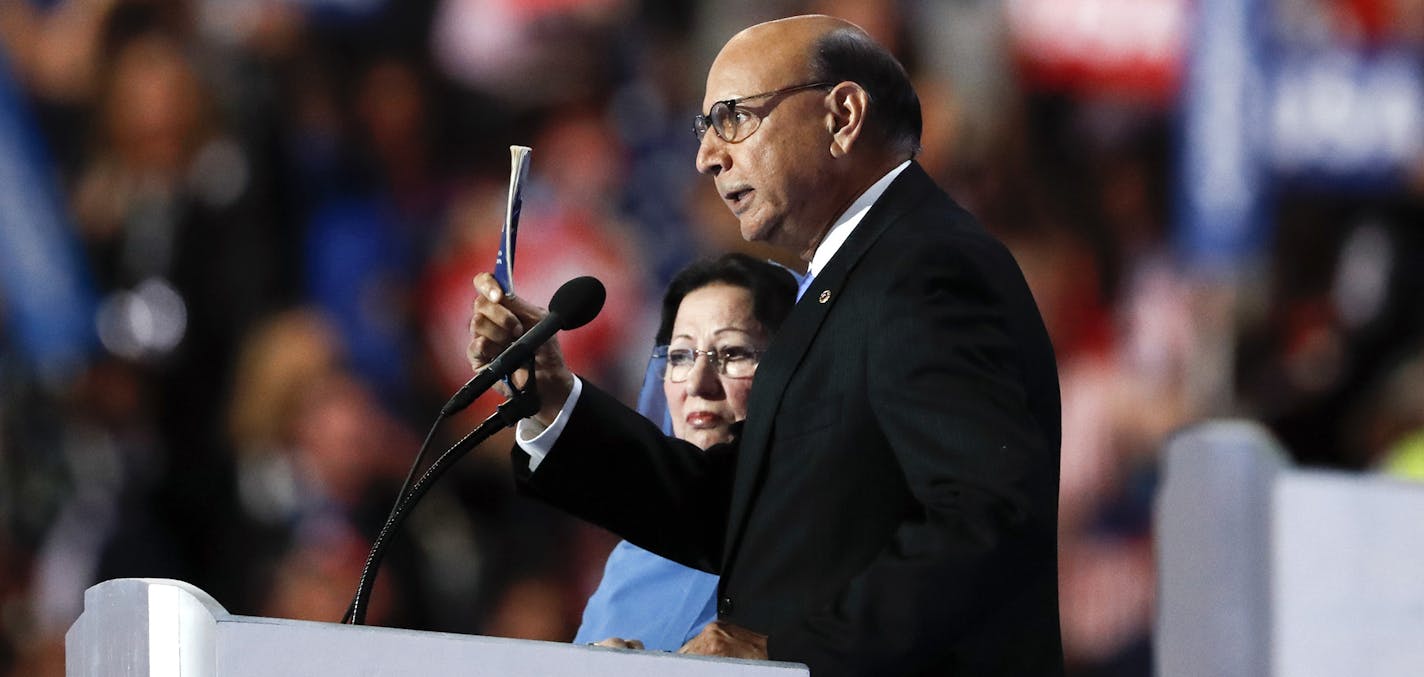 Khizr Khan, father of fallen US Army Capt. Humayun S. M. Khan, holds up his copy the United States Constitution, while his wife Ghazala Khan looks on, as he speaks during the final day of the Democratic National Convention in Philadelphia, Thursday, July 28, 2016. (AP Photo/Paul Sancya) ORG XMIT: MIN2016080215022419