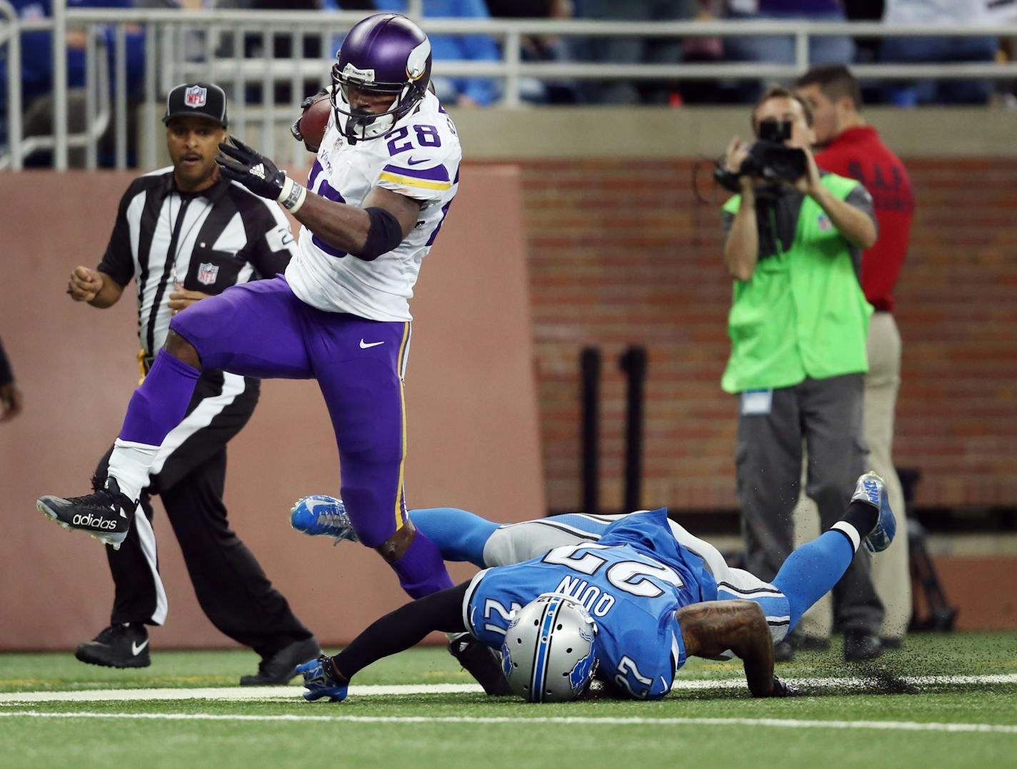 Minnesota Vikings running back Adrian Peterson (28) high-stepped past Detroit Lions free safety Glover Quin (27) for a 75 yard run in the third quarter at Ford Field Sunday October 25, 2015 in Detroit, MI.